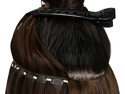 A butterfly weft attached to a beaded track, lifted to show how it sits underneath the natural hair